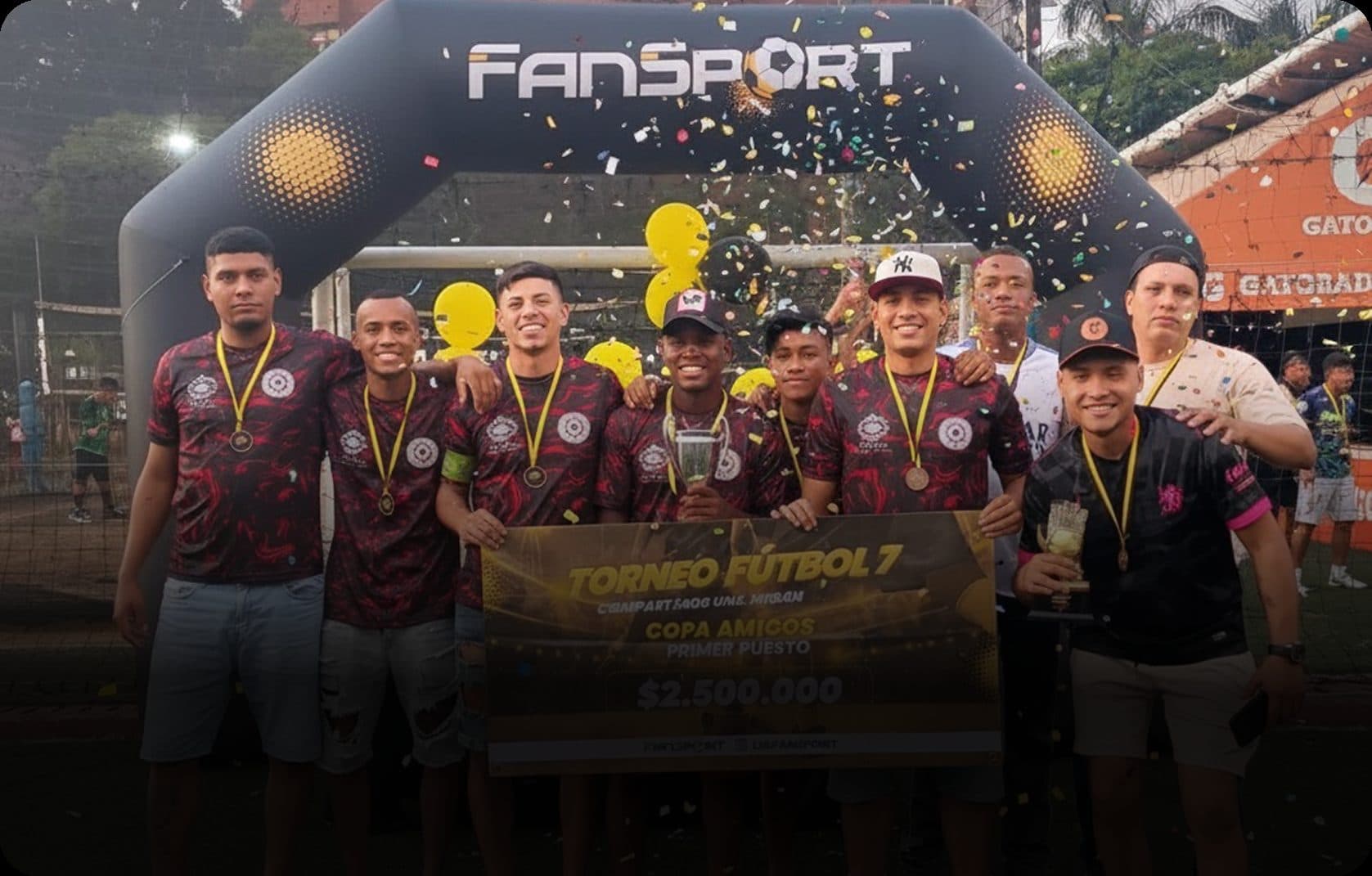 Equipo ganador del torneo de Fansport celebrando con su trofeo bajo el arco inflable del evento